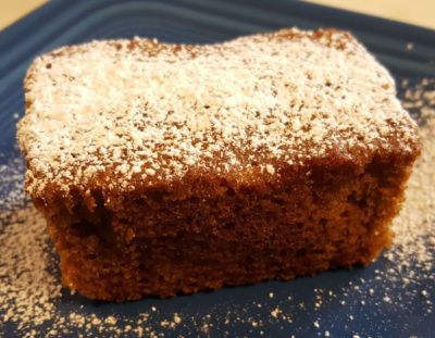 mini loaf shape brown cake sprinkled with powdered sugar on blue plate