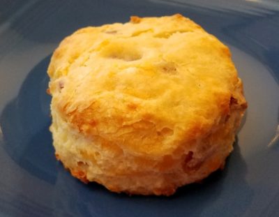 golden bacon cheddar biscuit on a blue plate