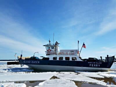 Island Queen Ferry on snow-covered water carrying trucks and cars