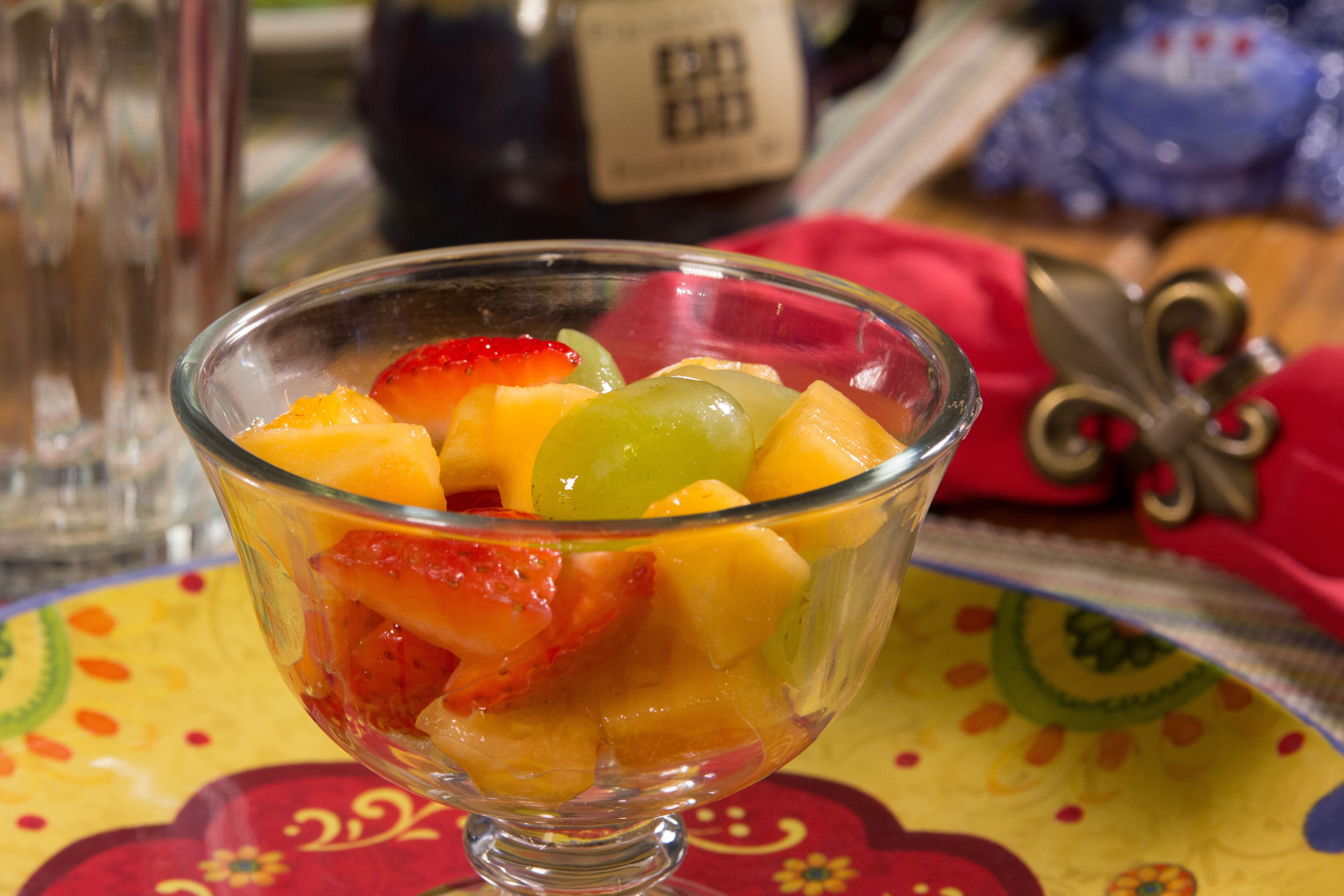 assorted fresh fruit in a clear bowl on a multicolored plate