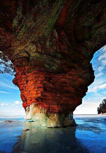 Coloful upside down looking rock formation on water amidst blue skies